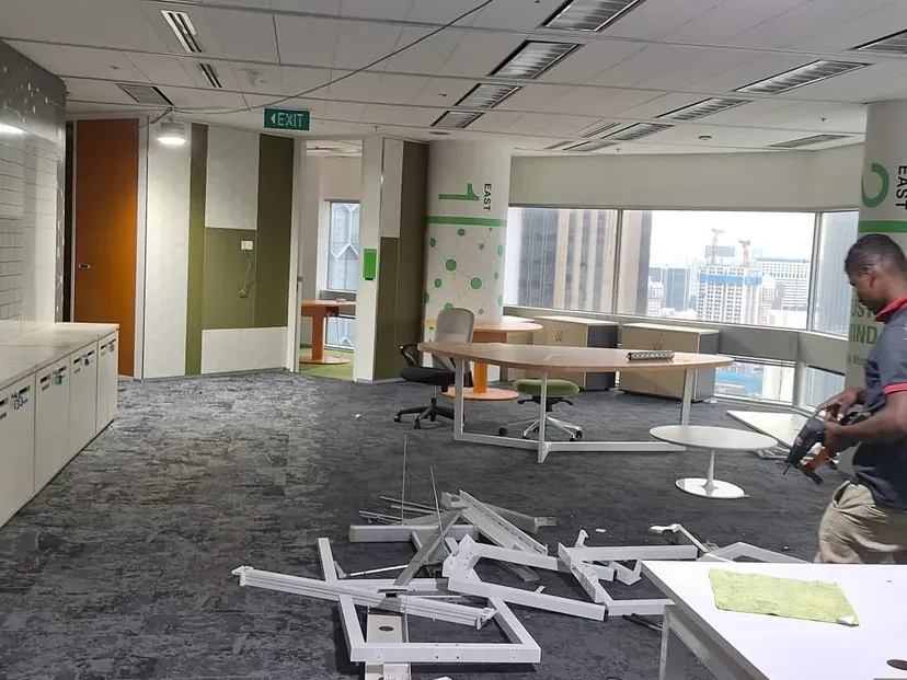 Reinstatement crew member clearing dismantled furniture from an office floor